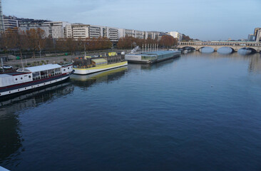 Fototapeta na wymiar downtown paris france from seine river with old wooden barges early morning and stone bridge with subway train