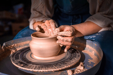 The hands of the master who makes the jug. Close-up.