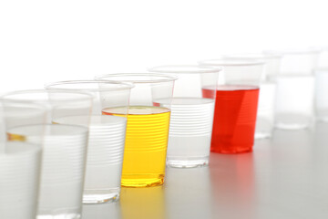 色の付いた水が入った瓶やコップ