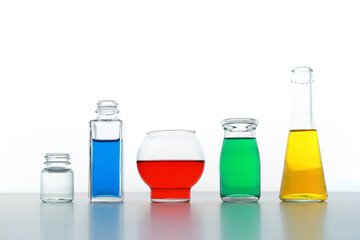 色の付いた水が入った瓶やコップ