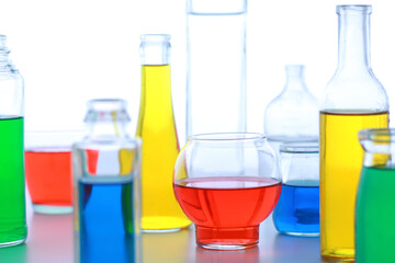 色の付いた水が入った瓶やコップ