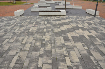 concrete white bench block and wave shape in the park on a dark cobbled square, clean concrete...