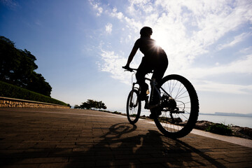 Fototapeta na wymiar Riding bike on the sunrise coast path