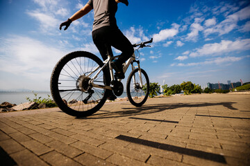 Fototapeta na wymiar Woman riding bike without holding the handlebar on the coast path