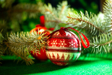 red Christmas balls for decoration on the background of green spruce branches