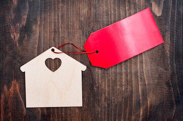 House with blank red sign on wooden background