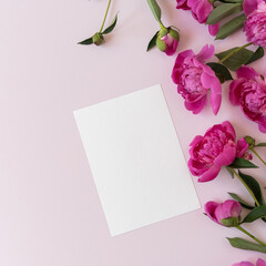 Blank branding paper card sheet with mockup copy space and elegant peonies flowers on pink background. Aesthetic flowers composition