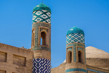 Close-up view of the corner towers of ancient madrasahs in Khiva, Uzbekistan. Multicolored bricks are lined with traditional Khorezm patterns