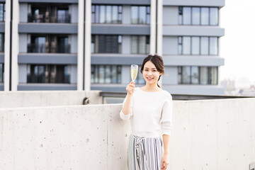 ペントハウスでワインを愉しむリッチな女性