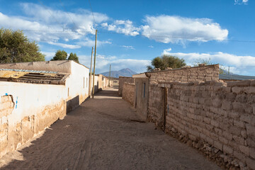 Bolivia, Altiplano, Potosi, San Juan. View of a street in the town of San Juan with mud brick homes lining the way.