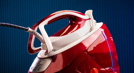 Red steam generator iron on a blue background