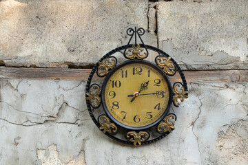 old broken clock ussr hangs on the white wall of a house in the street in the sun, broken old clock