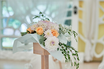 Beautiful floral arrangement of rose flowers and greenery on wedding table in restaurant, copy...