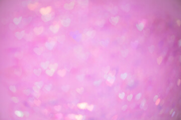 Natural pink bokeh of lights in the form of a heart, blurred out of focus background. Abstract beautiful backdrop for text or advertising. Postcard with love in light gentle colors