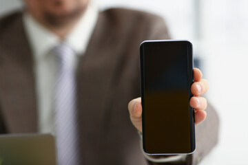 Male arm in suit show in camera mobile phone display with black screen