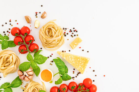 Iettuccine with ingredients for cooking Italian pasta on white background, top view