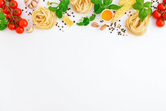 Iettuccine with ingredients for cooking Italian pasta on white background, top view