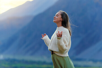 Serene peaceful tranquil woman with hands in lotus pose, closed eyes standing alone in thoughts and...