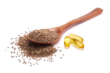 Wooden spoon full of organic natural chia seeds and and omega pills close-up