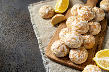 Lemon gingerbread on a serving wooden board on a dark culinary background. Delicious homemade cookies