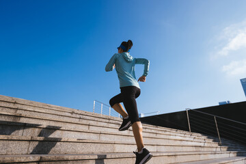 Fitness sports woman running up stairs in city