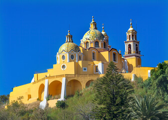 Fototapeta na wymiar Colorful yellow Iglesia de Nuestra Senora de los Remedios, Cholula, Puebla, Mexico. Church built 1500's
