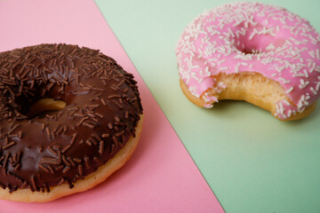 Bitten Dessert on a colored background. Dessert colorful snack. Delicious donut with sprinkles. Bakery cake. Sweet food dessert donuts. Close-up of donuts
