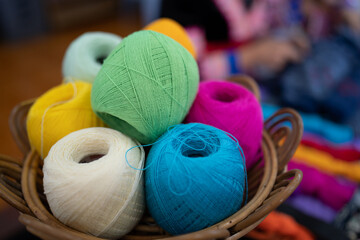 Balls of yarn for knitting. Balls of yarn for knitting in a wicker basket. A knitting yarn, knitted clothes, create coziness. Colorful multi-colored yarn for knitting.