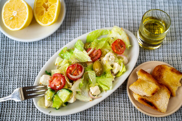 Plate with salad, pastry, olive oil and lemon