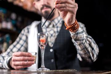 Experienced Female bartender makes a cocktail on the bar