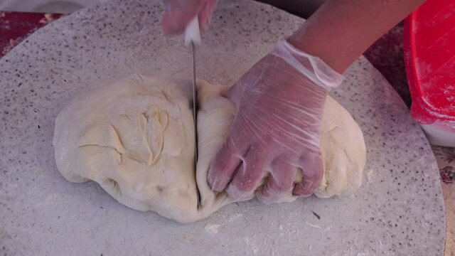Adult woman making chebureks - roasts chebureks in pan, prepares meat pies, working with the dough and filling, close-up. Fried flatbread piadina naan pita tortilla shelpek cheburek. Street food.
