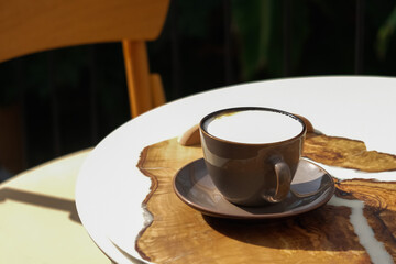 Cup of aromatic coffee cappuccino or latte on a wooden table. Concept of meeting or relaxing. Tasty morning drinks.