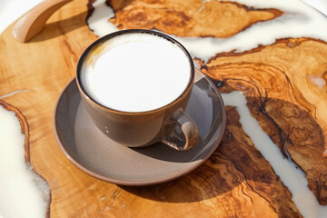 Cup of aromatic coffee cappuccino or latte on a wooden table. Concept of meeting or relaxing. Tasty morning drinks.