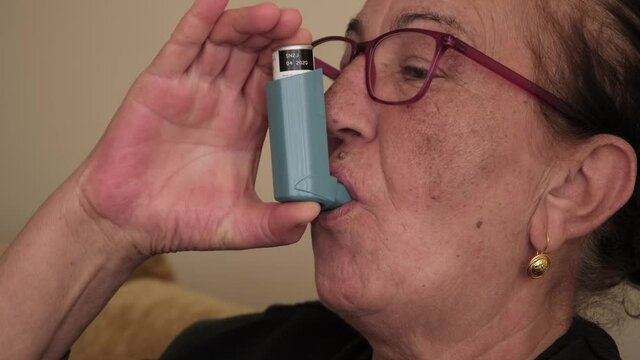 Asthmatic woman using an inhaler. Daily Life of a Person with long term inflammatory lung problems