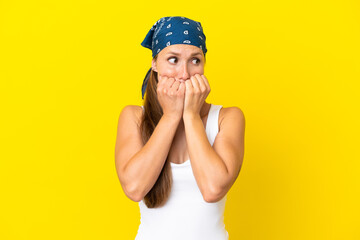 Young English woman isolated on yellow background nervous and scared putting hands to mouth