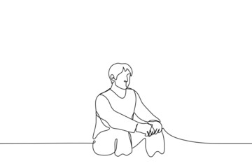 man sits on low seat with his legs wide apart, palms folded together - one line drawing vector. relaxation concept, procrastination, laziness, anticipation