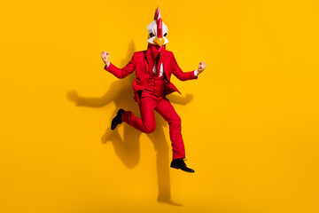Fototapeta na wymiar Photo of astonished office worker jump rejoice vacation wear chicken polygonal mask red tux isolated yellow color background