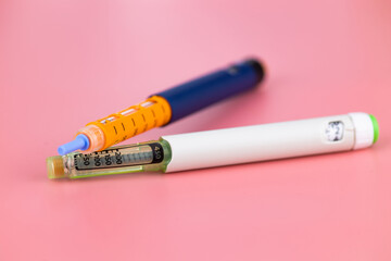 Insulin pen with insulin on a pink background. diabetes treatment