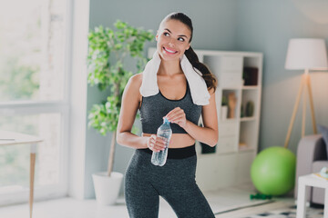 Photo of pretty dreamy girl dressed sport suit back chair drinking water thinking smiling indoors...