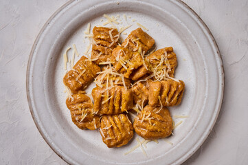 Macro flat lay Italian gnocchi from whole grain flour, baked pumpkin puree and parmesan. Selective focus