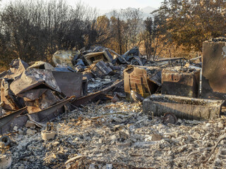 Fototapeta na wymiar Remains of house after wildfire in Southern Sierra Nevada Mountains, from drought stressed forest