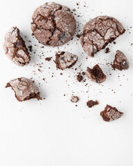 Broken chocolate chip cookie on white plate with crumbs