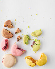 Broken macaroons with crumbs on white background