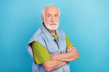 Photo of confident serious man pensioner dressed retro denim vest arms crossed isolated blue color...