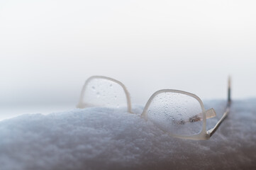 Women's glasses with white frames on the snow