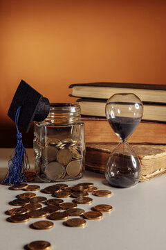 Jar with coins, graduation hat and hourglass. Savings and education theme
