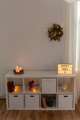 winter holidays, decoration and interior concept - room with shelf decorated for christmas at home