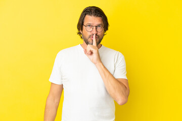 Senior dutch man isolated on yellow background showing a sign of silence gesture putting finger in mouth