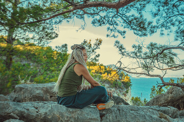 rasta girl with dreadlocks resting on the Mediterranean coast