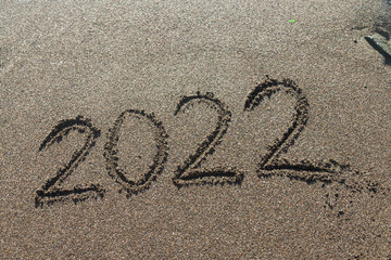 2022 written in the sand of a beach, new year travel greeting card